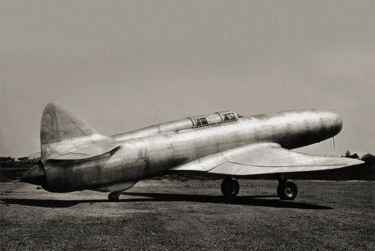 Il Caproni Campini N.1, aereo sperimentale a reazione tutto metallico e senza elica, fermo su un campo in una fotografia d'epoca