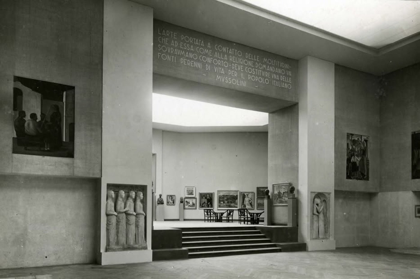 Sala di una grande esposizione d'arte degli anni Trenta, con un'iscrizione di Mussolini sulla funzione dell'arte